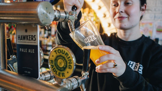 HBE crew member pouring a beer into an HBE glass at the His Boy Elroy bar, Wollongong